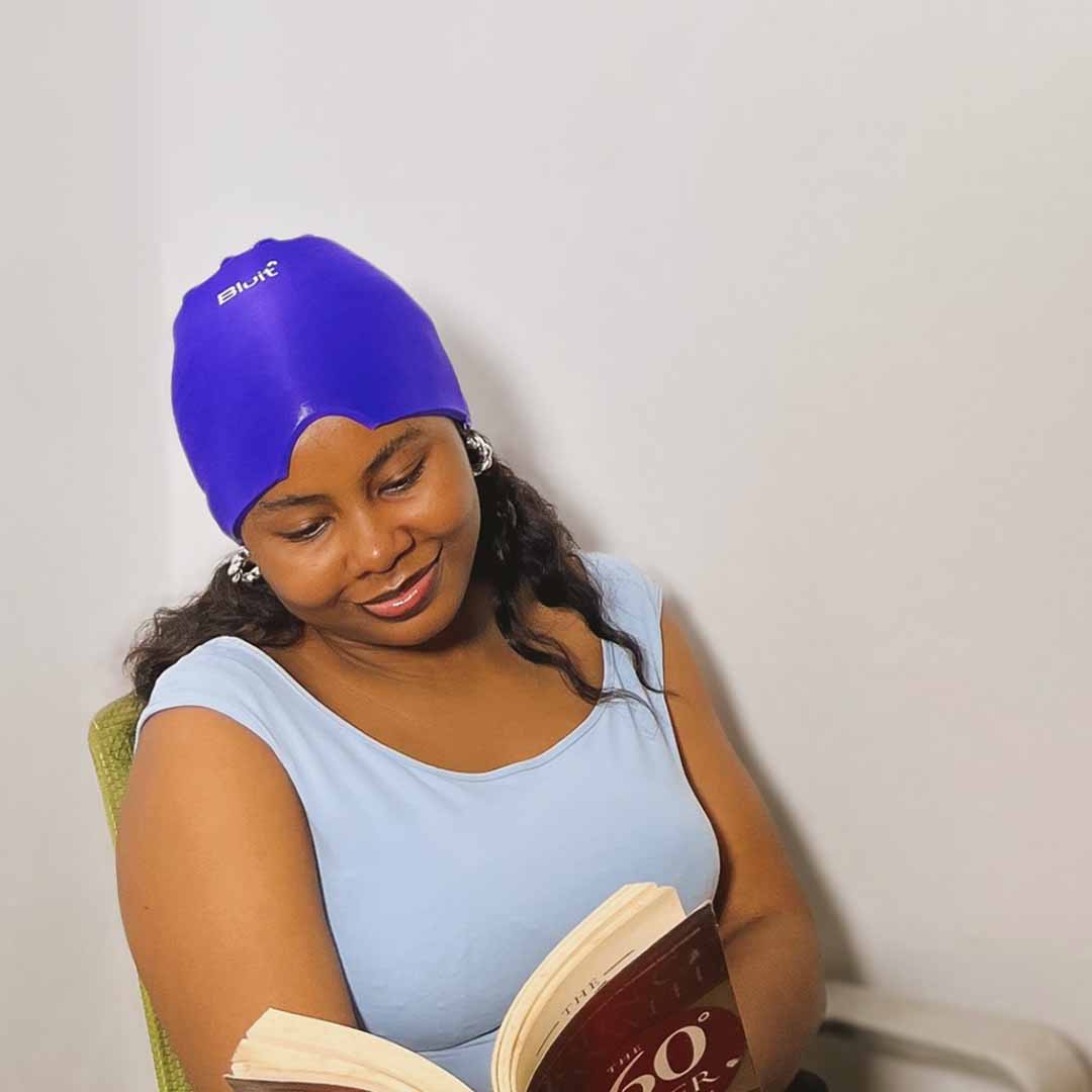 Woman relaxing while wearing a purple Bluit Migraine Relief Cap