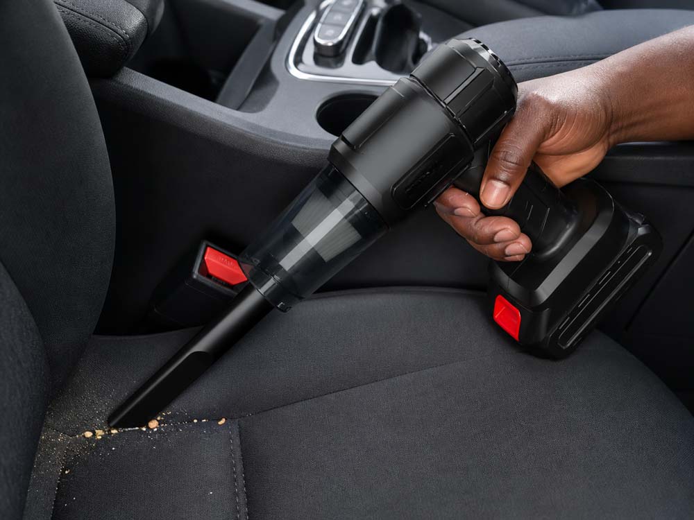 Cordless MiniVac cleaning crumbs from a car seat